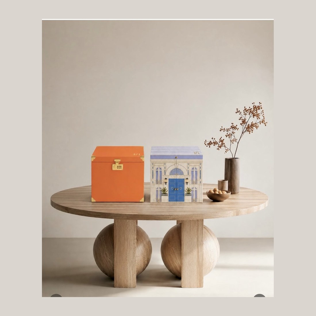 The Shubh Aarambh trunk in orange beside the townhouse box, on a round oak table